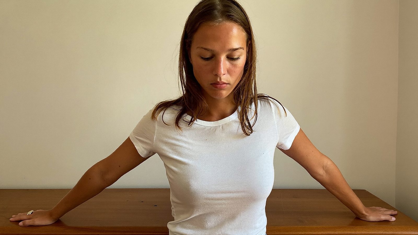 Woman with a natural, golden self-tanner glow standing in a bright room