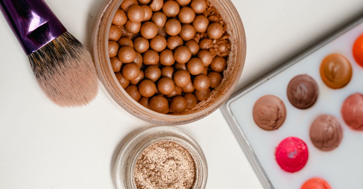 Bronzing pearls and a makeup brush in a flat lay