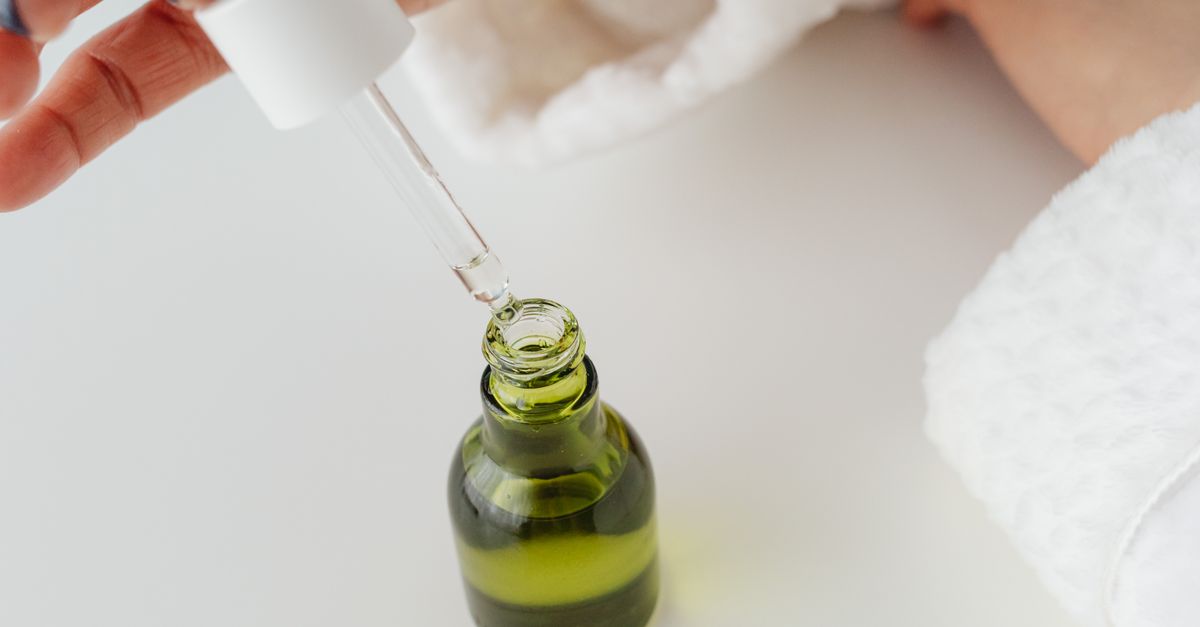 Dropper resting over a green glass serum bottle