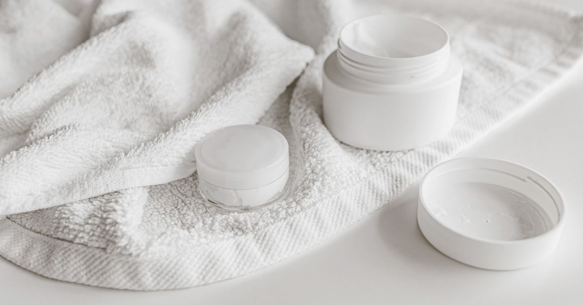 White cream jars on a white towel