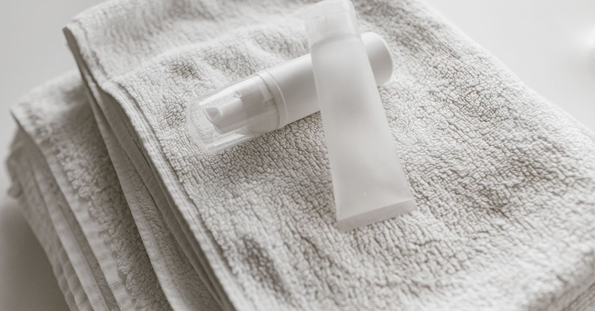 Plain product bottles resting on folded white towels