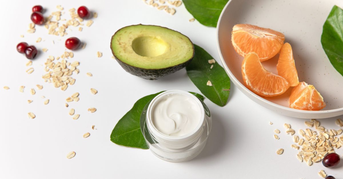Cream jar surrounded by avocado, oats and fruit