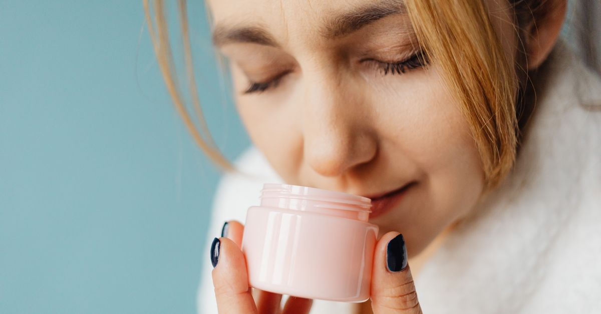 Woman breathing in the scent of a cream jar